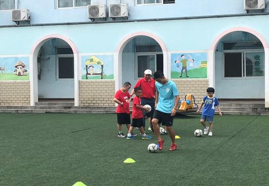 吴佑年老师带足球班员工在福利院指导儿童技能学习